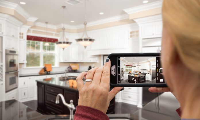 Vacation Rental Host Taking Pictures of A Custom Kitchen with Her Smart Phone